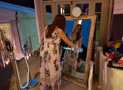 A lady at a wedding in Nottingham using the Magic Mirror Photo Booth to take a photograph